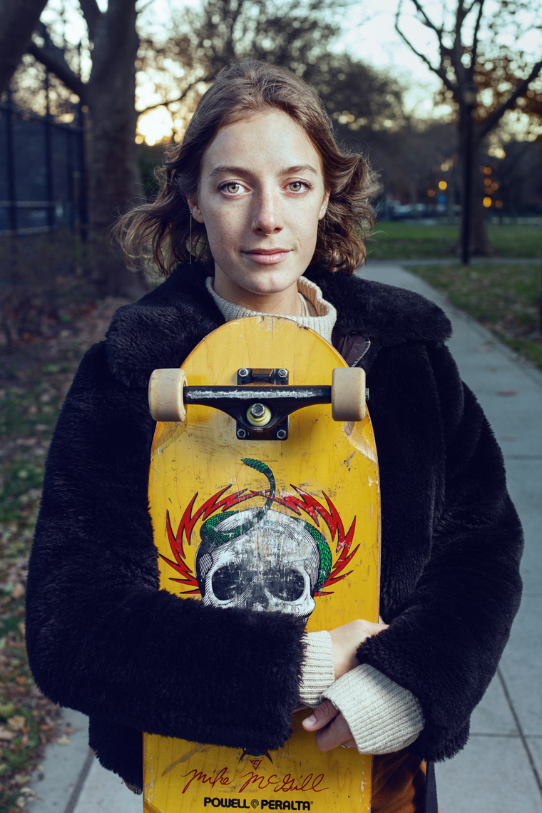 Skateboarder holding skateboard in Brooklyn Kristen Noelle Grlswirl Claudine_Williams Photography