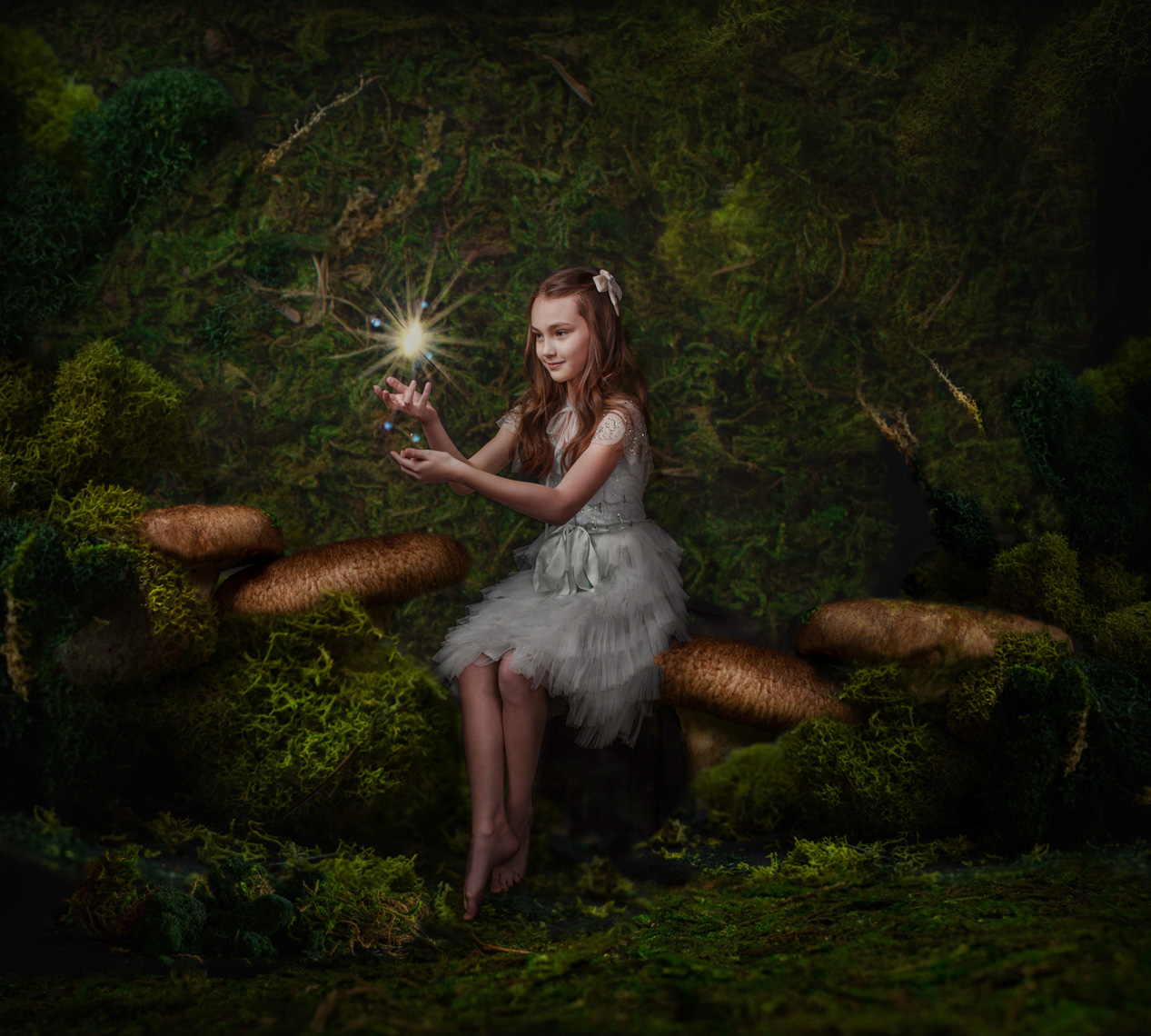 Conceptual Portrait of a girl as a fairy with mushrooms and moss